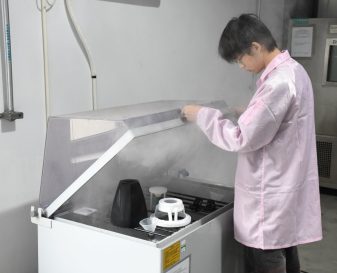reliability testing-salt spray Technician operating ultrasonic cleaning equipment for marine audio component maintenance